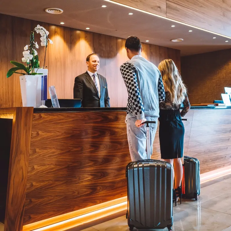 Travelers checking in at a hotel front desk