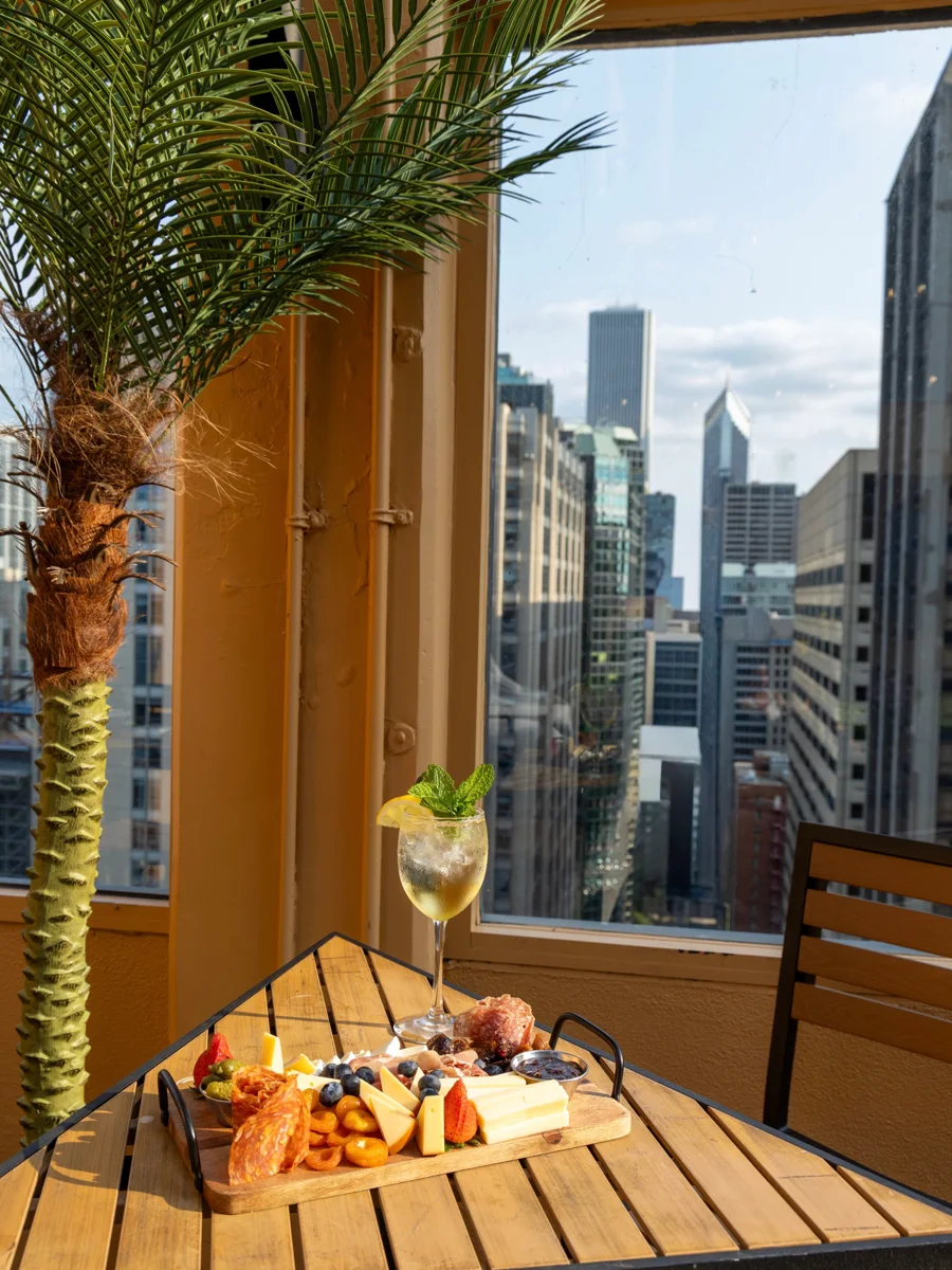 A charcuterie board and cocktail overlooking Chicago from SkyDeck at Twenty Nine