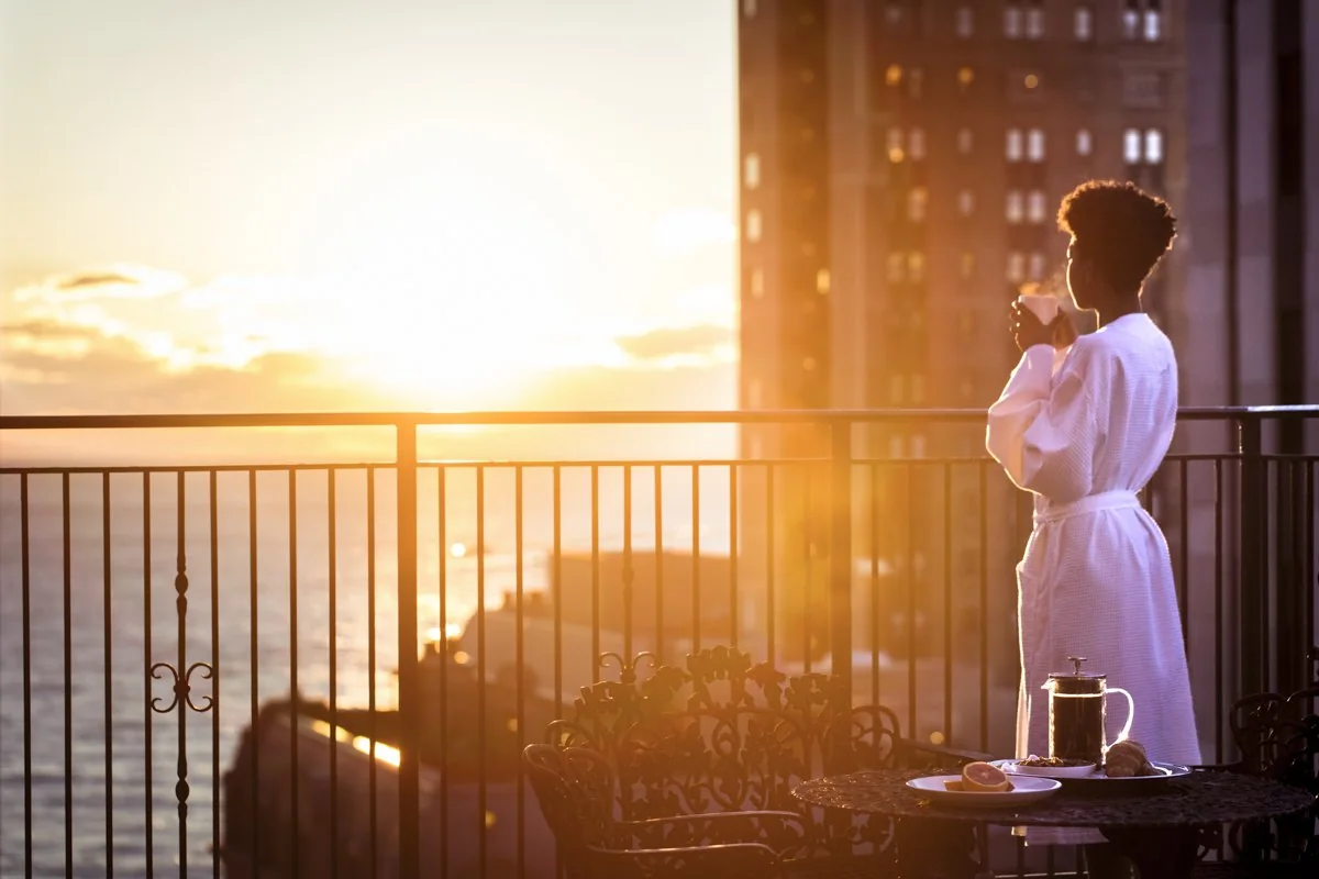 Guest enjoying morning coffee from a Chicago hotel terrace at sunrise